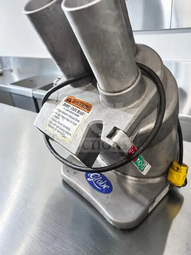 Globe GFP500 food processor in superior condition, commercial-grade, 600 lb/hr capacity, visible safety warning label, fully operational.