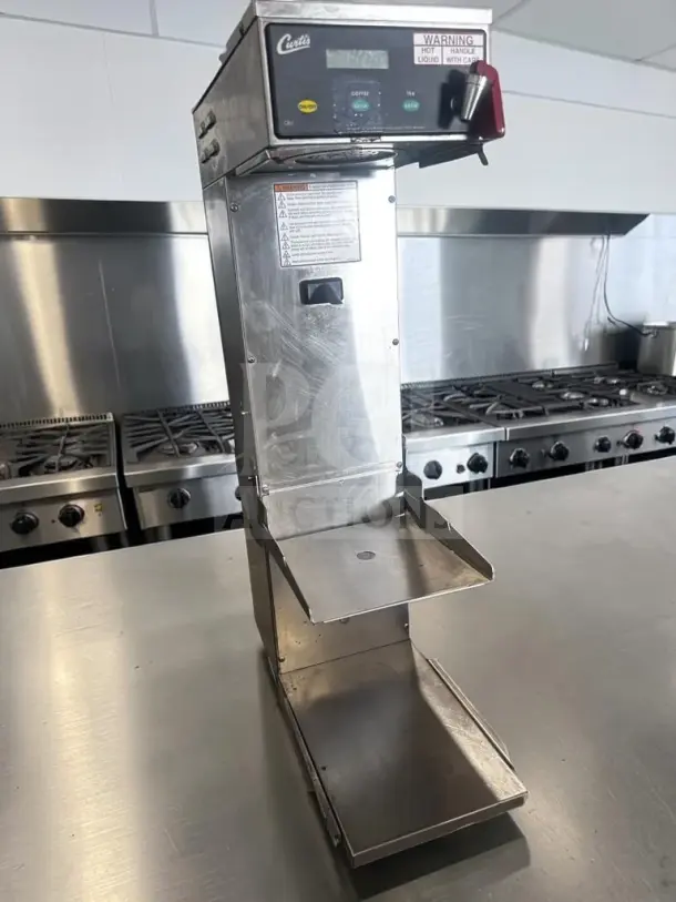 Wilbur Curtis CBS10000 commercial brewer, stainless steel, adjustable shelf, operational, tagged for coffee, tea, iced beverages.