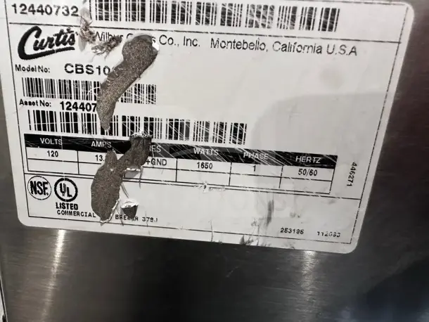 Wilbur Curtis CBS10000 label, showing 120V, 13.8A, 1650W, 50/60Hz specs. NSF and UL listed for commercial use.