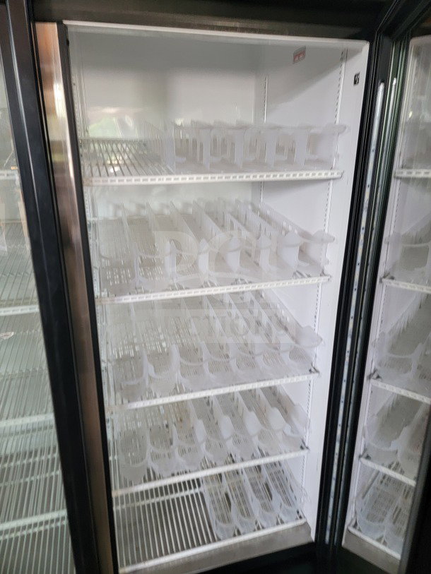 True GDM-72-HC 3-door glass merchandiser refrigerator, shelves visible, tested, working condition, ideal for commercial use.