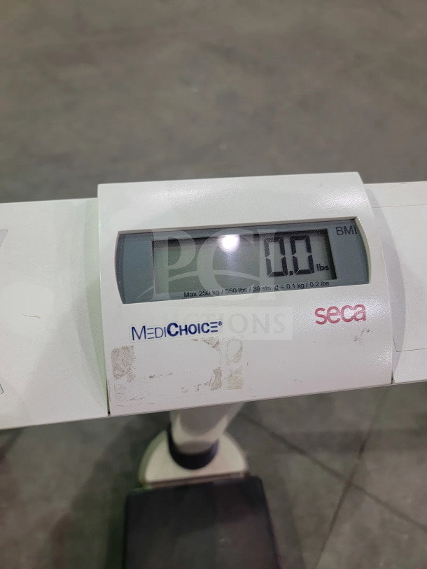 SECA 703 digital scale with BMI, hold, and tare functions; 550 lb capacity, robust design, and integrated wheels.