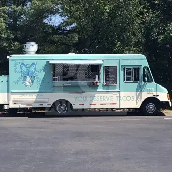 1999 Chevrolet P30 food truck, 24-foot, fully equipped commercial kitchen, "You Deserve Tacos" branding, teal color.