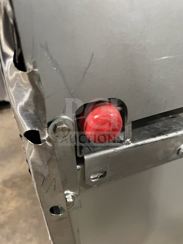 Close-up of a scratched, stainless steel surface with visible rivets and a red component, part of the Kutano KUT6BRN36NG range.