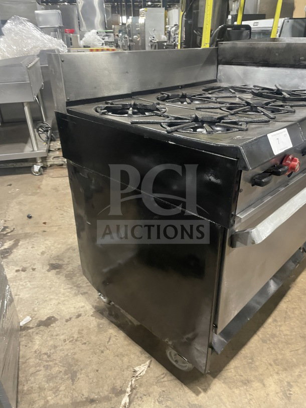 Garland stainless steel gas range with 6 burners, griddle, double oven, broiler, backsplash, and salamander shelf, on casters.