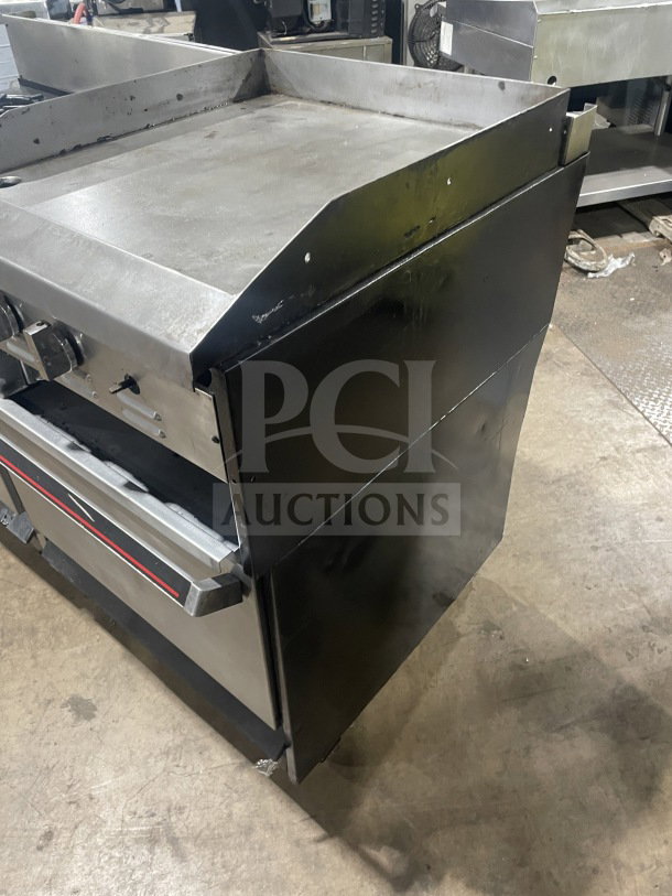 Garland stainless steel 6-burner range with raised flat griddle, double oven, broiler, and salamander shelf. Good condition.