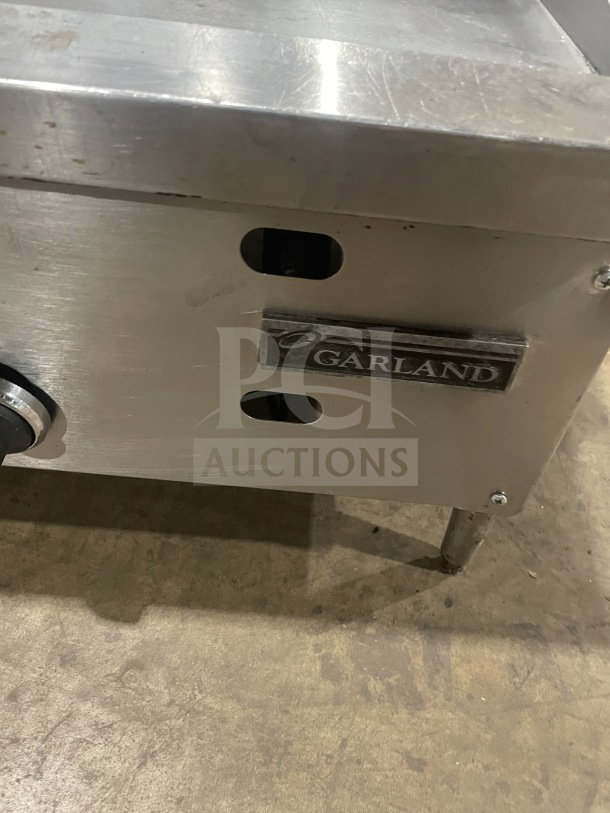 Garland stainless steel gas-powered countertop griddle on legs, features control knob and branded label, in used condition.