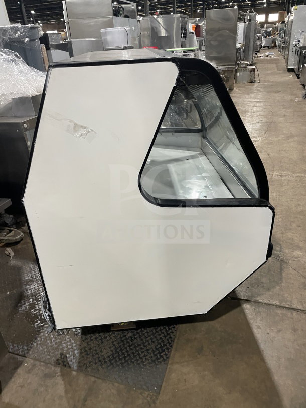 Tor-Rey 57" white refrigerated deli display, model TEC13OL UL, with curved glass, rear sliding doors, on legs, in used condition.