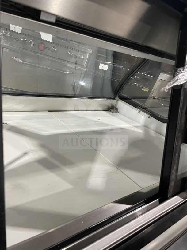 Tor-Rey 57" curved glass refrigerated deli merchandiser, model TEC13OL UL, with rear sliding glass doors, on legs.