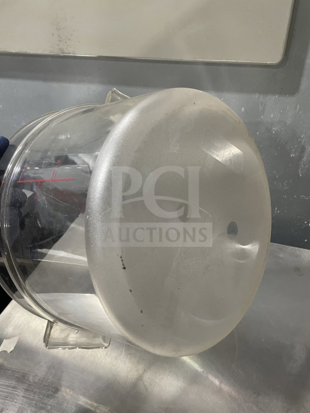 Round clear 12Qt polycarbonate food storage container, commercial-grade, slight wear. Ideal for kitchens.