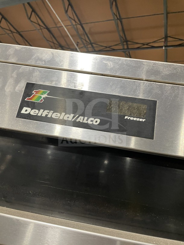 Delfield/Alco 4-door stainless steel refrigerator, dual-zoned, on casters, with a poly coated wired rack, visible logo.