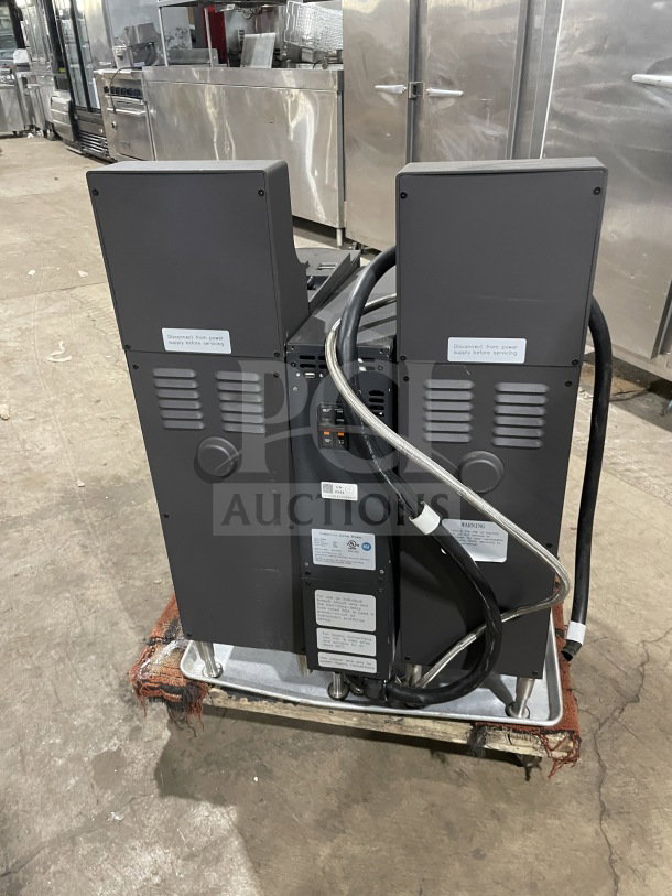 Clover Vertica Series CM9700 commercial coffee brewer with 6 flavor hoppers, on legs, 208V, visible tags, in used condition.
