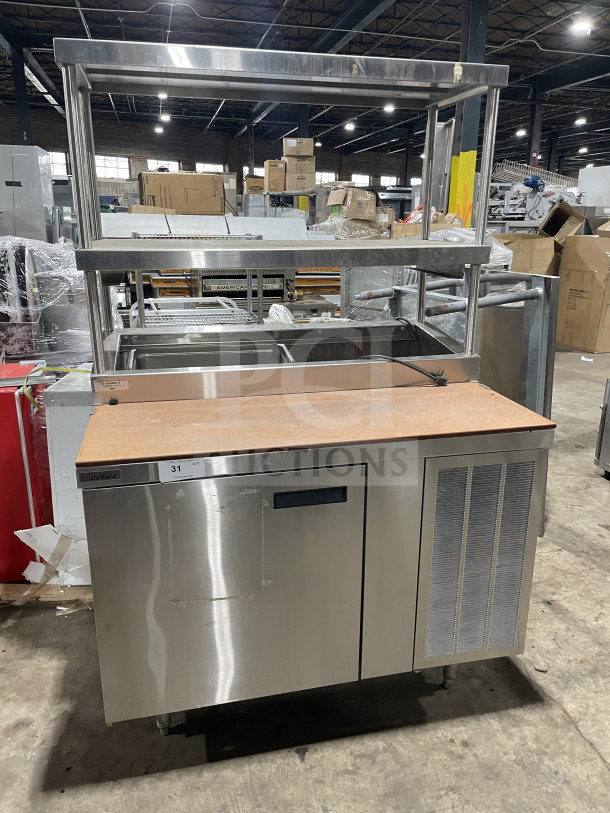 Delfield stainless steel pizza prep table with refrigerated base, double overhead shelf, chrome rack, and legs, 115V.