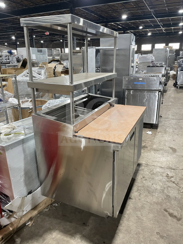 Delfield stainless steel pizza prep table with refrigerated storage, double overhead shelf, chrome-plated rack, and legs.
