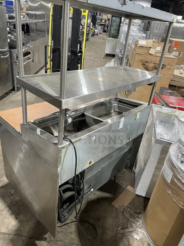Delfield stainless steel pizza prep table with refrigerated base, double overhead shelf, chrome rack, and legs. 115V 1 Phase.