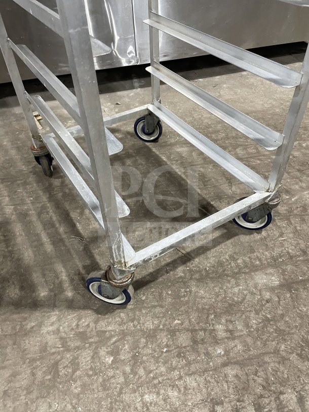 Kelmax by SPG stainless steel end-load bun pan rack with wire slides, on blue casters, Channel make, commercial use.