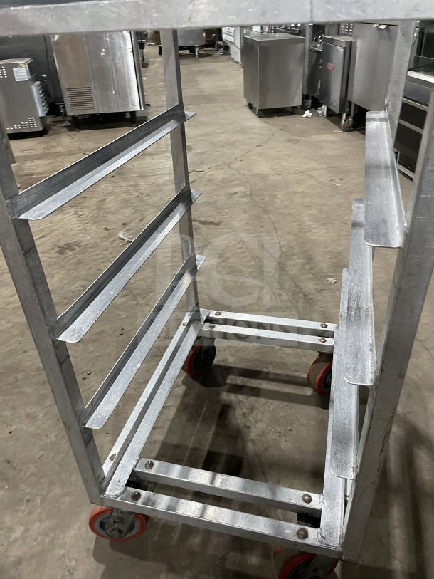 Channel commercial stainless steel end load mobile bun/sheet pan rack with wire slides, on red casters, in used condition.