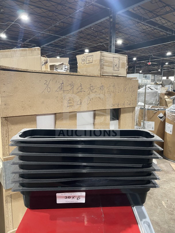 Carlisle black full-size food pan stack, good condition, 6 pieces. Label: "38 X 6" from PCIAuctions.com.