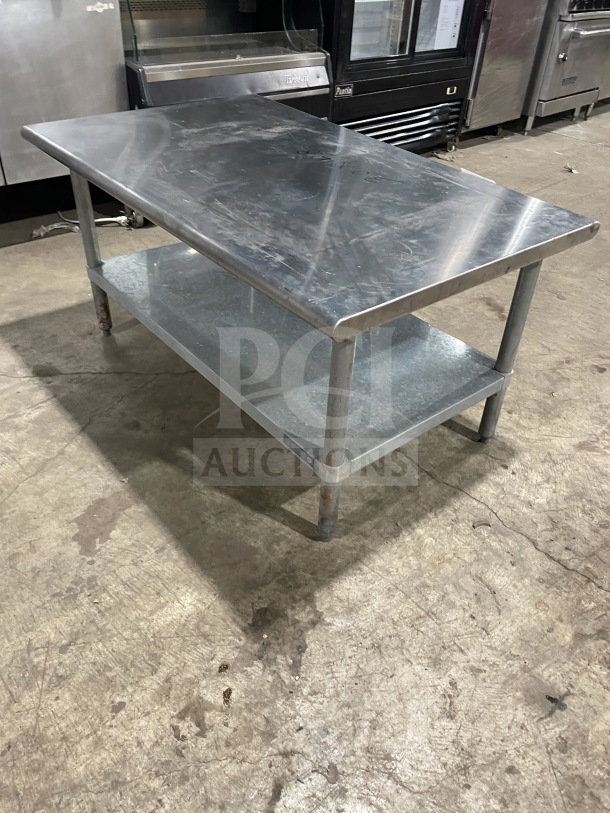 L&J Commercial stainless steel worktop table with undershelf. Features robust legs. Shows signs of wear.