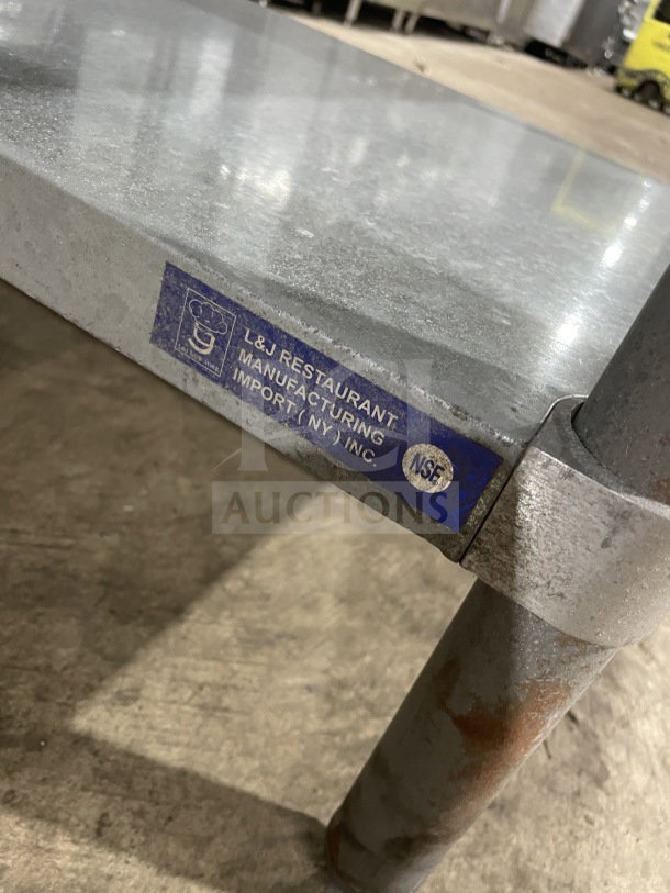 L&J stainless steel undershelf worktop table, on legs, with L&J Restaurant Manufacturing Import label visible, NSF certified.