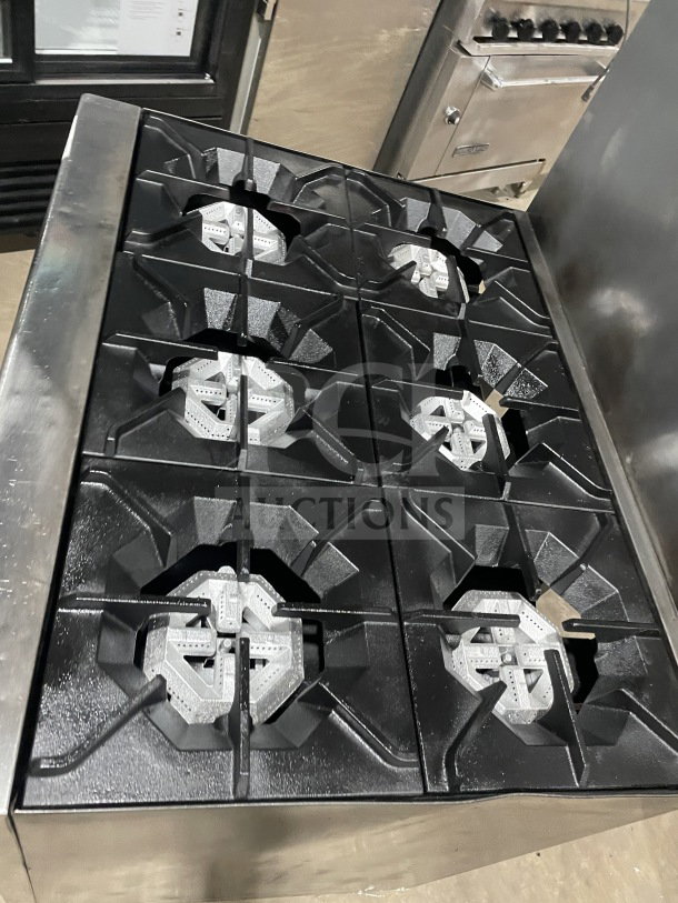 Commercial stainless steel gas-powered 6-burner range/oven combo with backsplash, overhead salamander shelf, wired oven rack, and casters.
