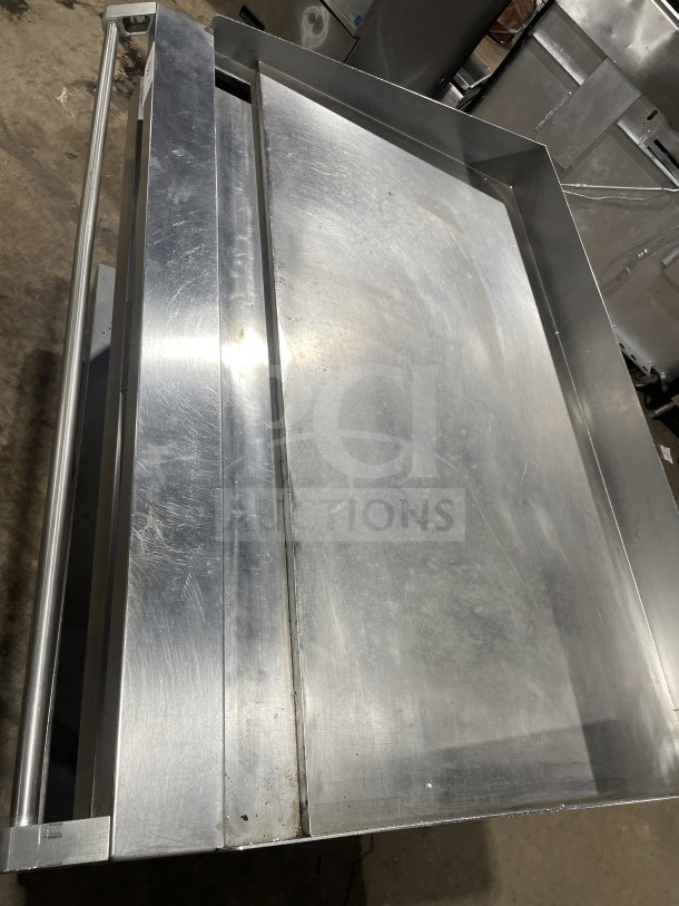 Vulcan 48RRGCKR1 48" stainless steel flat griddle, back and side splashes, equipment stand, storage space, on casters.