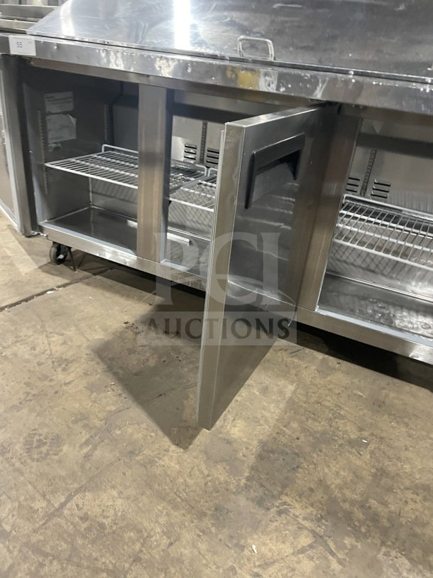 Commercial stainless steel 3-door prep refrigerator, model SC72BMI, with poly coated racks, on casters, open door view.