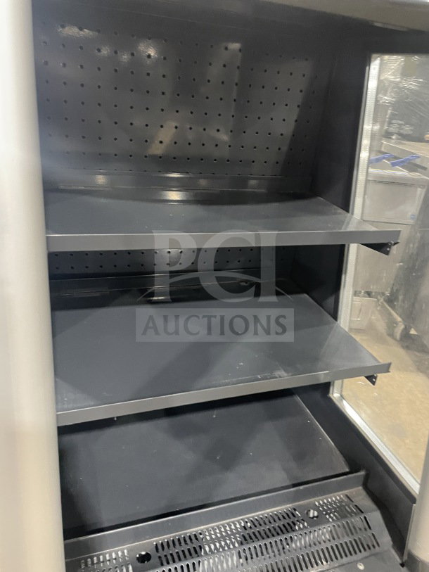 AHT refrigerated open merchandiser, Model AC-S LED, on casters, with pull-down night shade and LED lights, shelves visible.