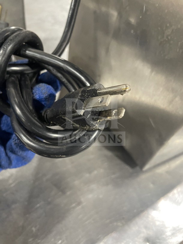Close-up of Robot Coupe CL52 commercial food processor's power cord, showcasing 120V plug, against stainless steel surface.