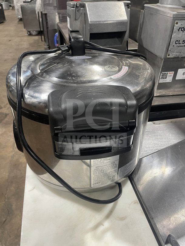 Amko AK-50RC stainless steel electric rice cooker, model SN 23079163, 120V, used condition, visible cable and power plug.