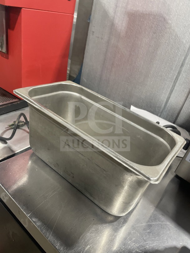 Commercial stainless steel food storage tray for sauces or salads. Slightly worn, durable, rectangular design.