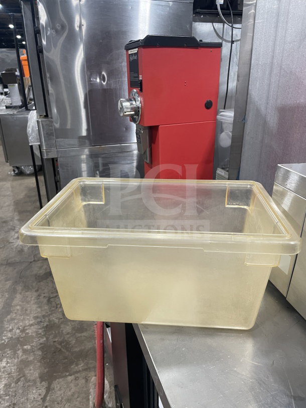 Commercial polycarbonate jumbo food storage container, transparent, rectangular, used condition, on stainless steel table.