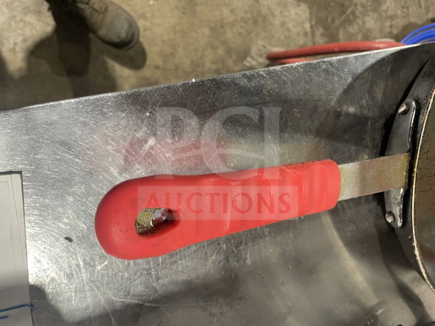Commercial non-stick aluminum fry pan with red silicone handle sleeve, metal surface, in good condition.
