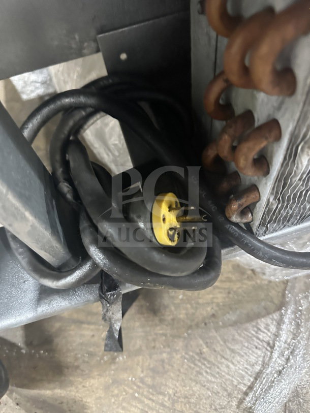 Coiled power cord of Beverage Air 60" sandwich prep table, showing plug and copper components, indicating electrical connection.
