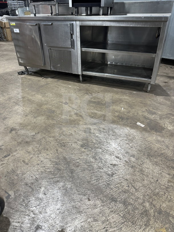Delfield stainless steel undercounter refrigerator chef base with integrated open shelves and chrome plated wire rack.