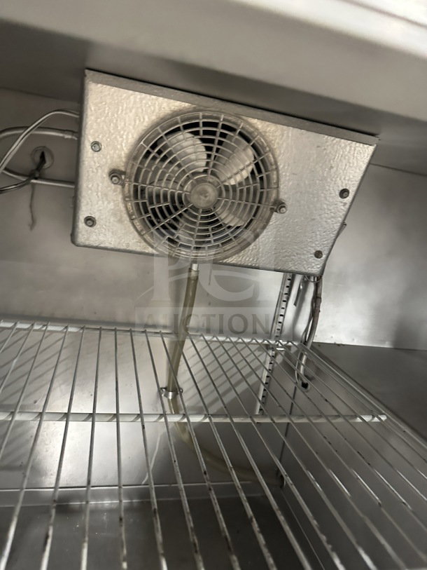 Delfield stainless steel undercounter refrigerator, featuring chrome-plated wire rack and integrated open storage shelves.