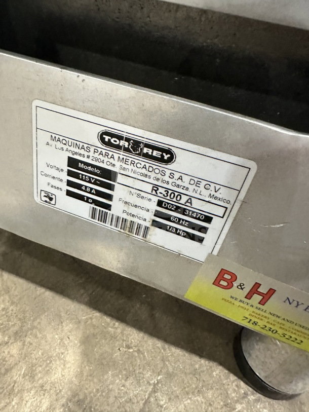 Tor-Rey R-300A electric meat slicer, 115V, 1 phase, model tag visible. Sits on legs, ideal for deli use.
