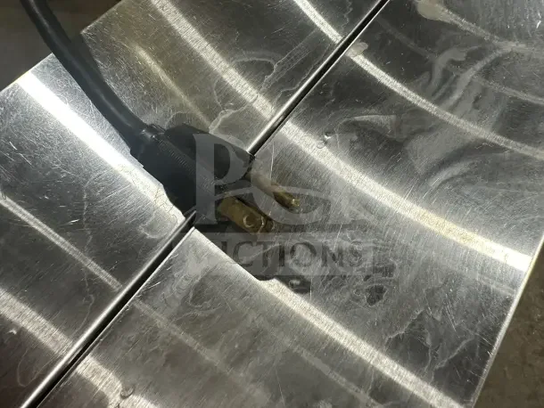 A power plug rests on a metallic surface, possibly part of the Bunn G9 coffee grinder mentioned in the item information.
