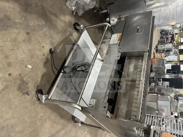 Commercial stainless steel electric griddle with split divider, back and side splashes on mobile stand with casters, visible power cord.