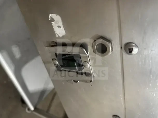 Commercial stainless steel electric countertop griddle close-up, showing control switch, on mobile equipment stand with casters.