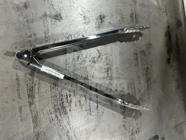 Brand new Cambro Lugano Series 12" stainless steel tongs, model 12TGS110, black handles. Durable commercial-grade tool.