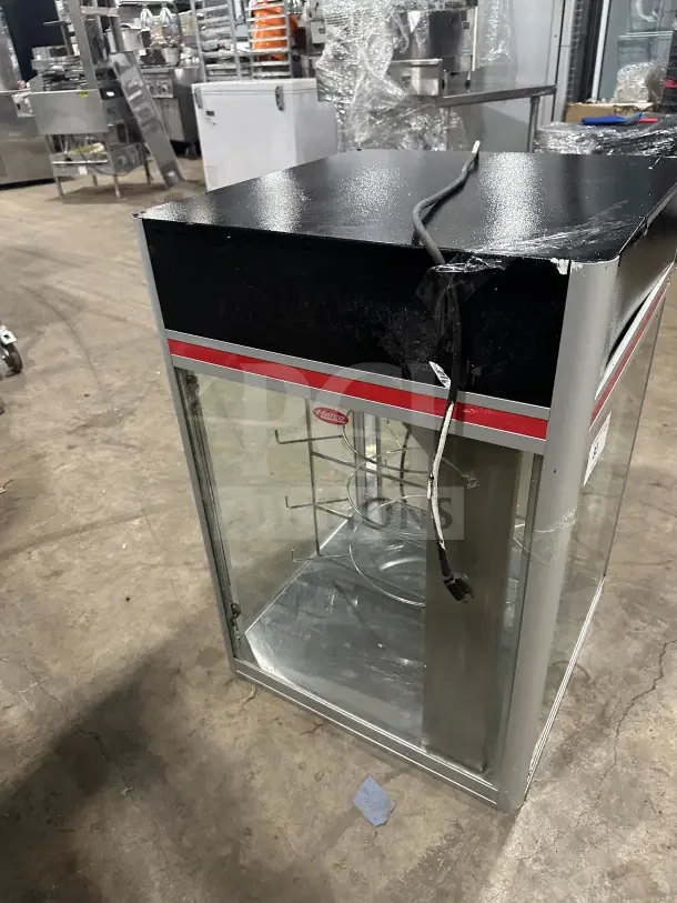 4-tier countertop electric heated pizza merchandiser with glass sides, black top, and visible wiring. Used condition.