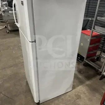 Frigidaire white top-freezer refrigerator, model FRT18G2NW9, shown in side view. Features poly-coated wired rack.