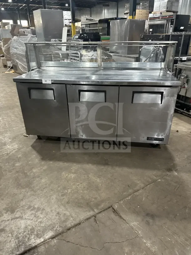 True TWT-72 commercial stainless steel 3-door worktop refrigerator with upturned backsplash, poly-coated rack, on casters.