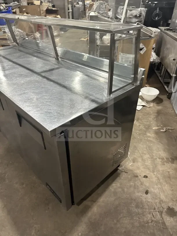 True TWT-72 stainless steel 3-door worktop refrigerator with upturned backsplash, poly-coated rack, and casters. Energy Star certified.