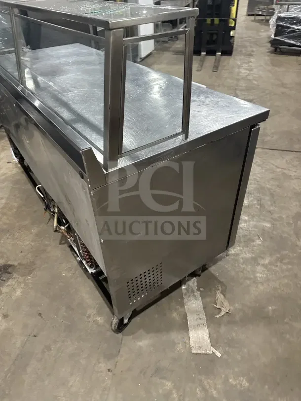 True TWT-72 stainless steel 3-door worktop refrigerator with up-turned backsplash, poly-coated rack, and casters.
