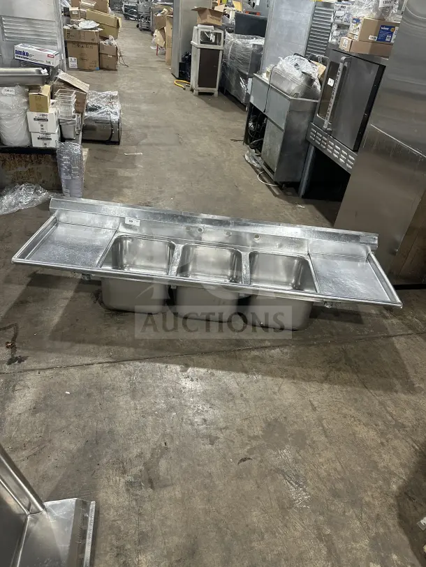 Commercial stainless steel 3-compartment sink with two side drainboards and supporting legs. Great condition.