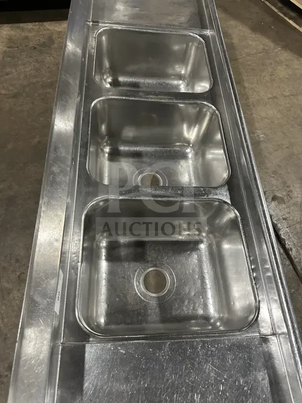 Commercial stainless steel 3-compartment sink with two side drainboards and legs, ideal for professional kitchens.