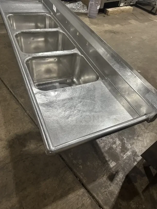 Commercial stainless steel 3-compartment sink with two side drainboards and durable legs. Excellent condition.
