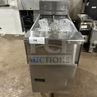 Pitco SE14T stainless steel split tank electric fryer with backsplash, basket hanger, new fry basket, individual controls, on legs.
