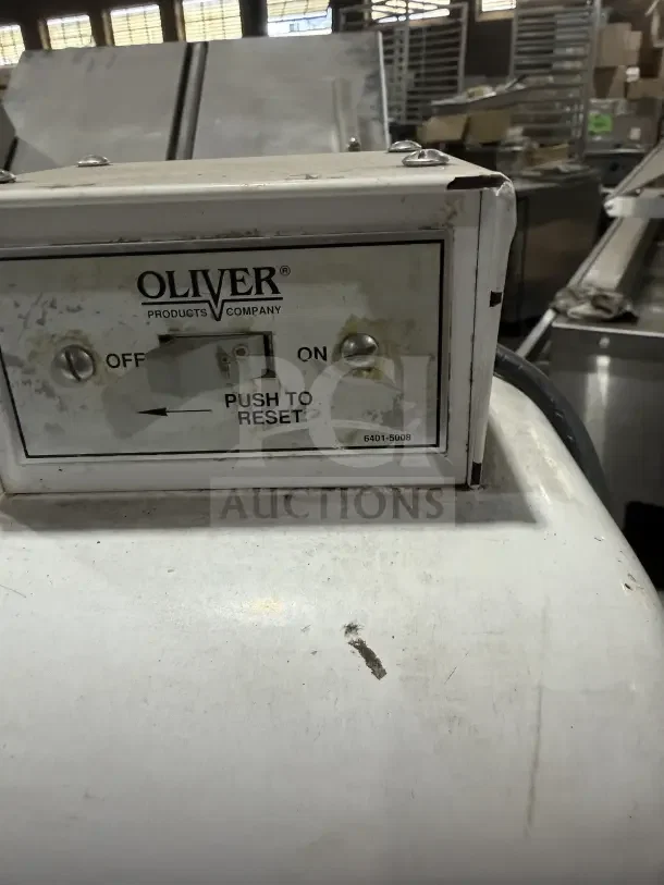 Oliver Model 79732NC bread slicer, electric, gravity feed, stainless steel worktop, 115V, on casters, used condition.